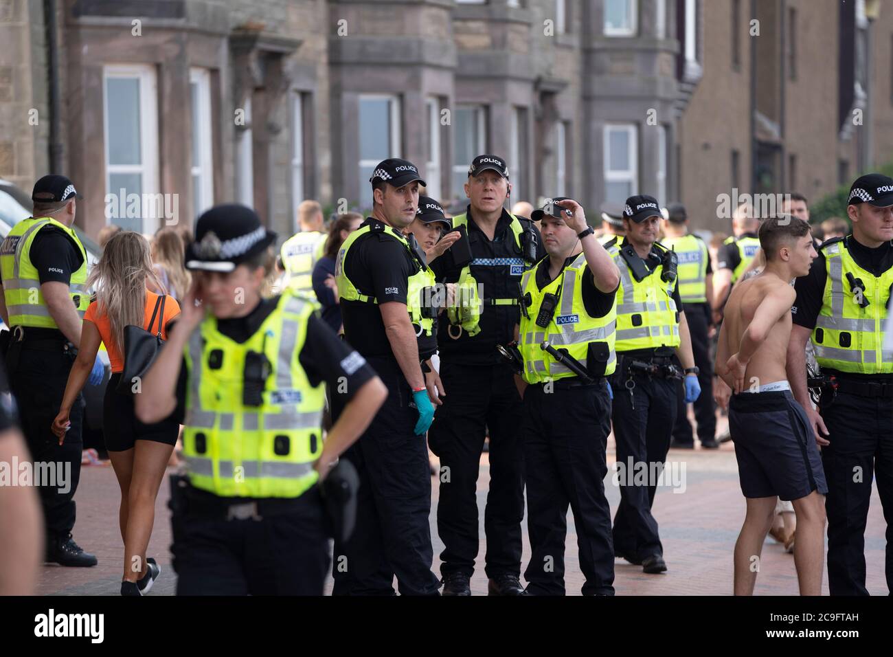 Edimburgo, Scozia, Regno Unito. 31 luglio 2020. La temperatura di 25°C e il sole hanno portato enormi folle a Portobello Beach fuori Edimburgo. Molti grandi gruppi di adolescenti stavano godendo la spiaggia e le bevande alcoliche erano molto popolari. Nella foto, intorno alle 15:00 si sono verificati problemi tra i giovani sulla spiaggia e i rinforzi della polizia sono stati rapidamente in scena e molte persone sono state rapite. Westbank Street è stata chiusa al traffico e circa 30 poliziotti stanno pattugliando la passeggiata. La polizia confisca l'alcool degli adolescenti che rimangono sulla spiaggia. Iain Masterton/Alamy Live News Foto Stock