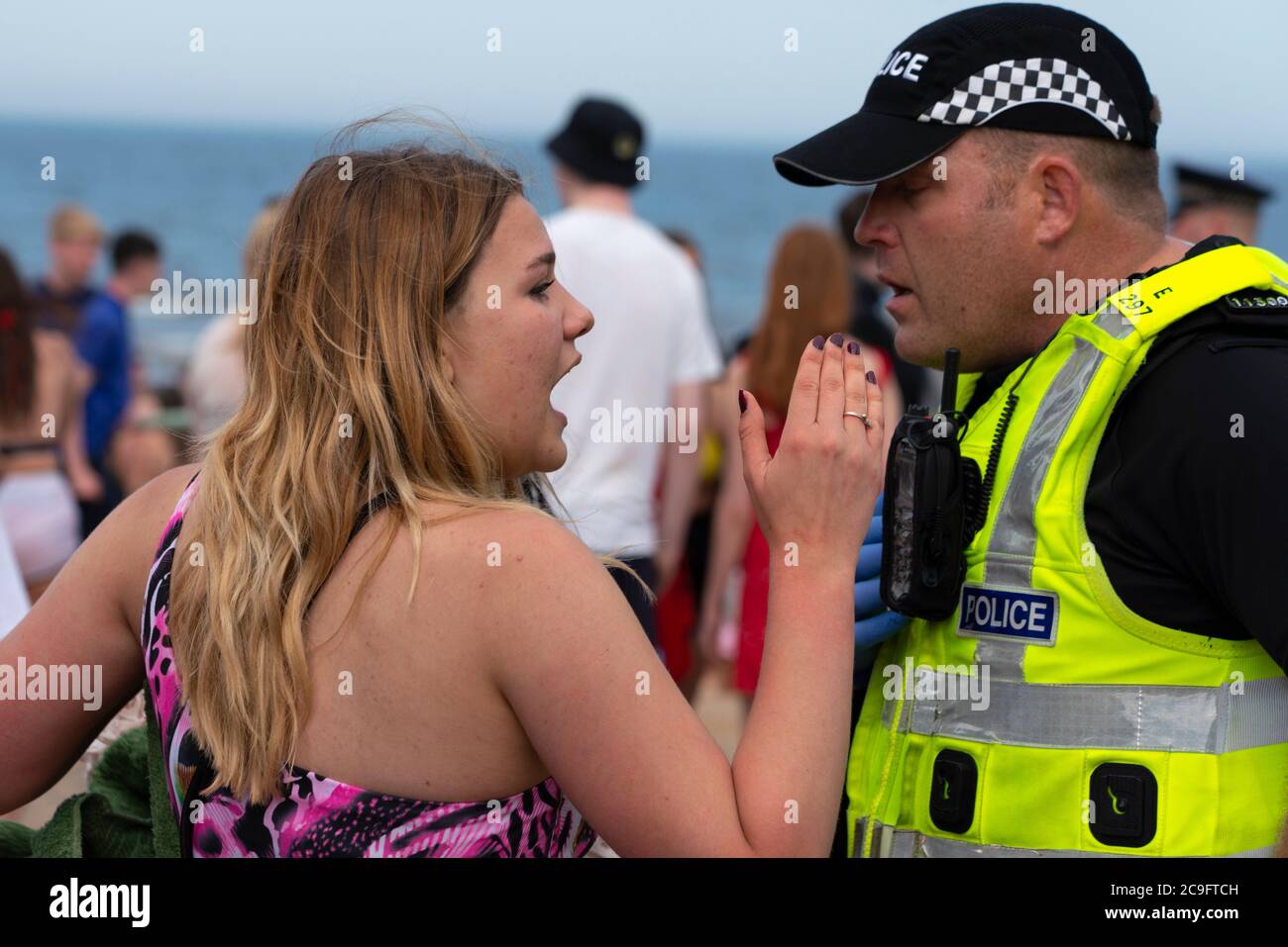 Edimburgo, Scozia, Regno Unito. 31 luglio 2020. La temperatura di 25°C e il sole hanno portato enormi folle a Portobello Beach fuori Edimburgo. Molti grandi gruppi di adolescenti stavano godendo la spiaggia e le bevande alcoliche erano molto popolari. Nella foto, intorno alle 15:00 si sono verificati problemi tra i giovani sulla spiaggia e i rinforzi della polizia sono stati rapidamente in scena e molte persone sono state rapite. Westbank Street è stata chiusa al traffico e circa 30 poliziotti stanno pattugliando la passeggiata. La polizia confisca l'alcool degli adolescenti che rimangono sulla spiaggia. Iain Masterton/Alamy Live News Foto Stock