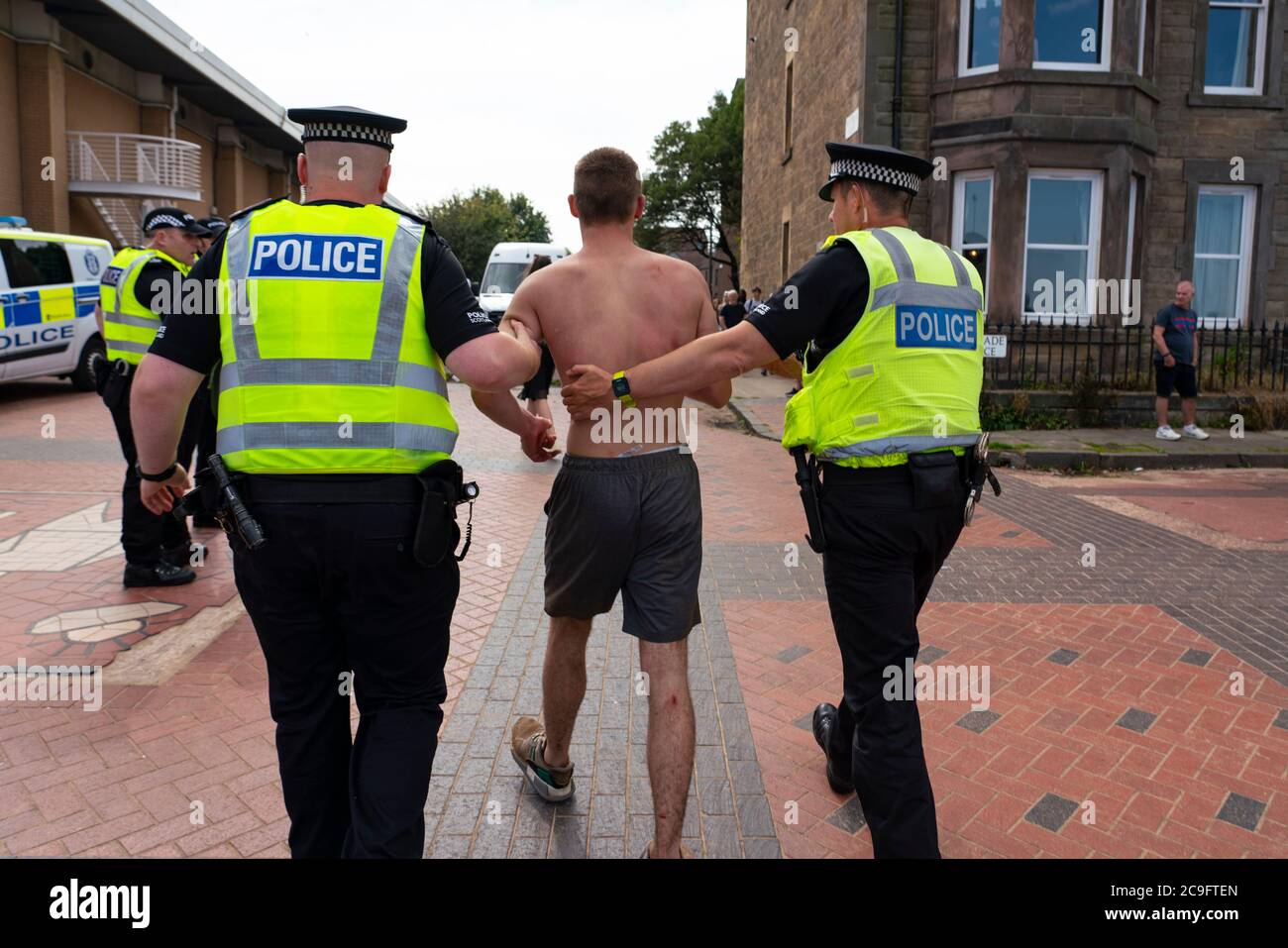 Edimburgo, Scozia, Regno Unito. 31 luglio 2020. La temperatura di 25°C e il sole hanno portato enormi folle a Portobello Beach fuori Edimburgo. Molti grandi gruppi di adolescenti stavano godendo la spiaggia e le bevande alcoliche erano molto popolari. Nella foto, intorno alle 15:00 si sono verificati problemi tra i giovani sulla spiaggia e i rinforzi della polizia sono stati rapidamente in scena e molte persone sono state rapite. Westbank Street è stata chiusa al traffico e circa 30 poliziotti stanno pattugliando la passeggiata. La polizia confisca l'alcool degli adolescenti che rimangono sulla spiaggia. Iain Masterton/Alamy Live News Foto Stock