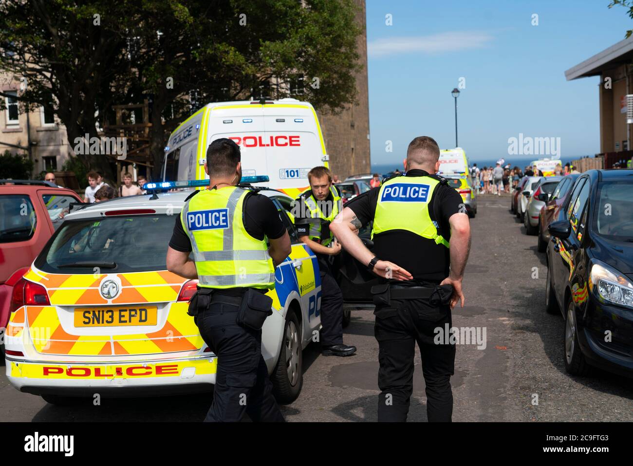 Edimburgo, Scozia, Regno Unito. 31 luglio 2020. La temperatura di 25°C e il sole hanno portato enormi folle a Portobello Beach fuori Edimburgo. Molti grandi gruppi di adolescenti stavano godendo la spiaggia e le bevande alcoliche erano molto popolari. Nella foto, intorno alle 15:00 si sono verificati problemi tra i giovani sulla spiaggia e i rinforzi della polizia sono stati rapidamente in scena e molte persone sono state rapite. Westbank Street è stata chiusa al traffico e circa 30 poliziotti stanno pattugliando la passeggiata. La polizia confisca l'alcool degli adolescenti che rimangono sulla spiaggia. Iain Masterton/Alamy Live News Foto Stock