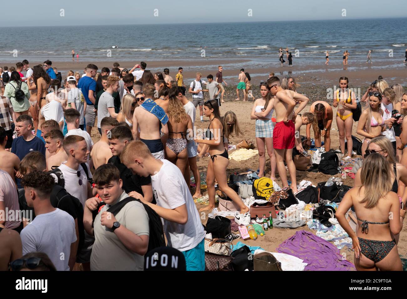 Edimburgo, Scozia, Regno Unito. 31 luglio 2020. La temperatura di 25°C e il sole hanno portato enormi folle a Portobello Beach fuori Edimburgo. Molti grandi gruppi di adolescenti stavano godendo la spiaggia e le bevande alcoliche erano molto popolari. Nella foto, intorno alle 15:00 si sono verificati problemi tra i giovani sulla spiaggia e i rinforzi della polizia sono stati rapidamente in scena e molte persone sono state rapite. Westbank Street è stata chiusa al traffico e circa 30 poliziotti stanno pattugliando la passeggiata. La polizia confisca l'alcool degli adolescenti che rimangono sulla spiaggia. Iain Masterton/Alamy Live News Foto Stock
