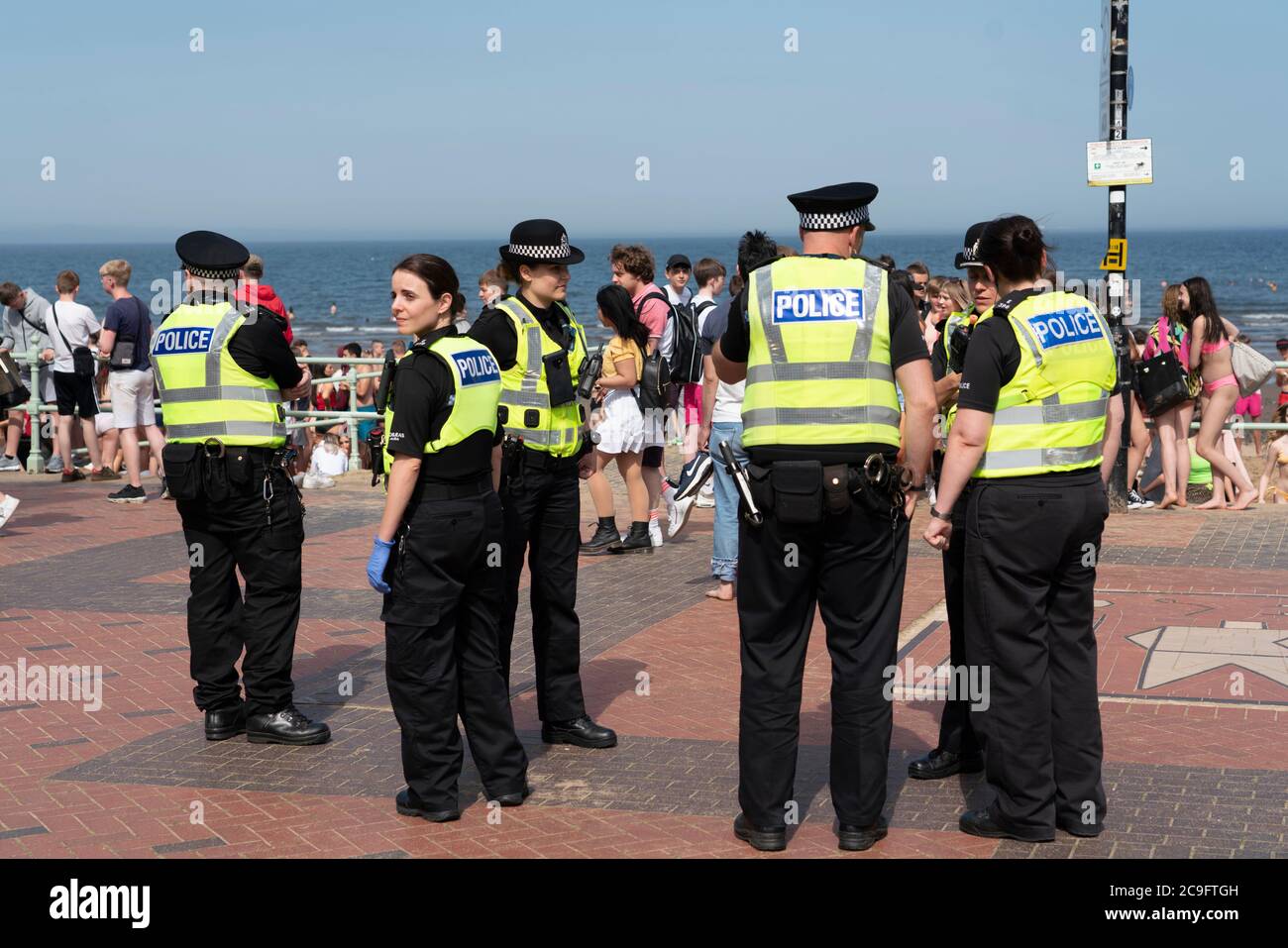 Edimburgo, Scozia, Regno Unito. 31 luglio 2020. La temperatura di 25°C e il sole hanno portato enormi folle a Portobello Beach fuori Edimburgo. Molti grandi gruppi di adolescenti stavano godendo la spiaggia e le bevande alcoliche erano molto popolari. Nella foto, intorno alle 15:00 si sono verificati problemi tra i giovani sulla spiaggia e i rinforzi della polizia sono stati rapidamente in scena e molte persone sono state rapite. Westbank Street è stata chiusa al traffico e circa 30 poliziotti stanno pattugliando la passeggiata. La polizia confisca l'alcool degli adolescenti che rimangono sulla spiaggia. Iain Masterton/Alamy Live News Foto Stock
