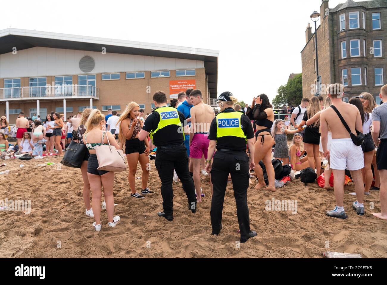 Edimburgo, Scozia, Regno Unito. 31 luglio 2020. La temperatura di 25°C e il sole hanno portato enormi folle a Portobello Beach fuori Edimburgo. Molti grandi gruppi di adolescenti stavano godendo la spiaggia e le bevande alcoliche erano molto popolari. Nella foto, intorno alle 15:00 si sono verificati problemi tra i giovani sulla spiaggia e i rinforzi della polizia sono stati rapidamente in scena e molte persone sono state rapite. Westbank Street è stata chiusa al traffico e circa 30 poliziotti stanno pattugliando la passeggiata. La polizia confisca l'alcool degli adolescenti che rimangono sulla spiaggia. Iain Masterton/Alamy Live News Foto Stock