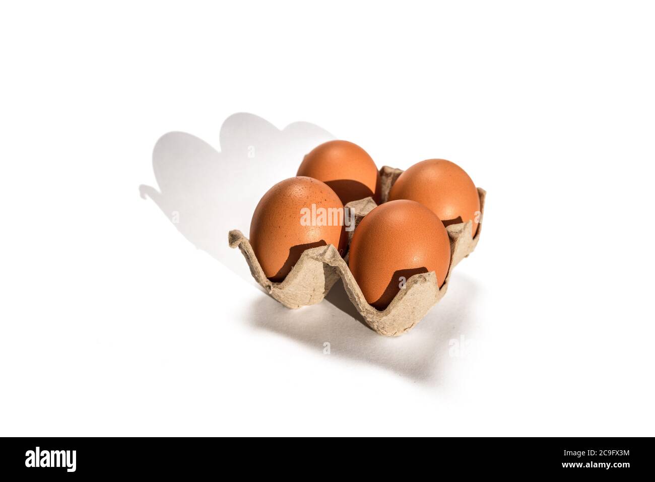 Uova di pollo marroni in cartone su sfondo bianco. Spazio di copia Foto Stock