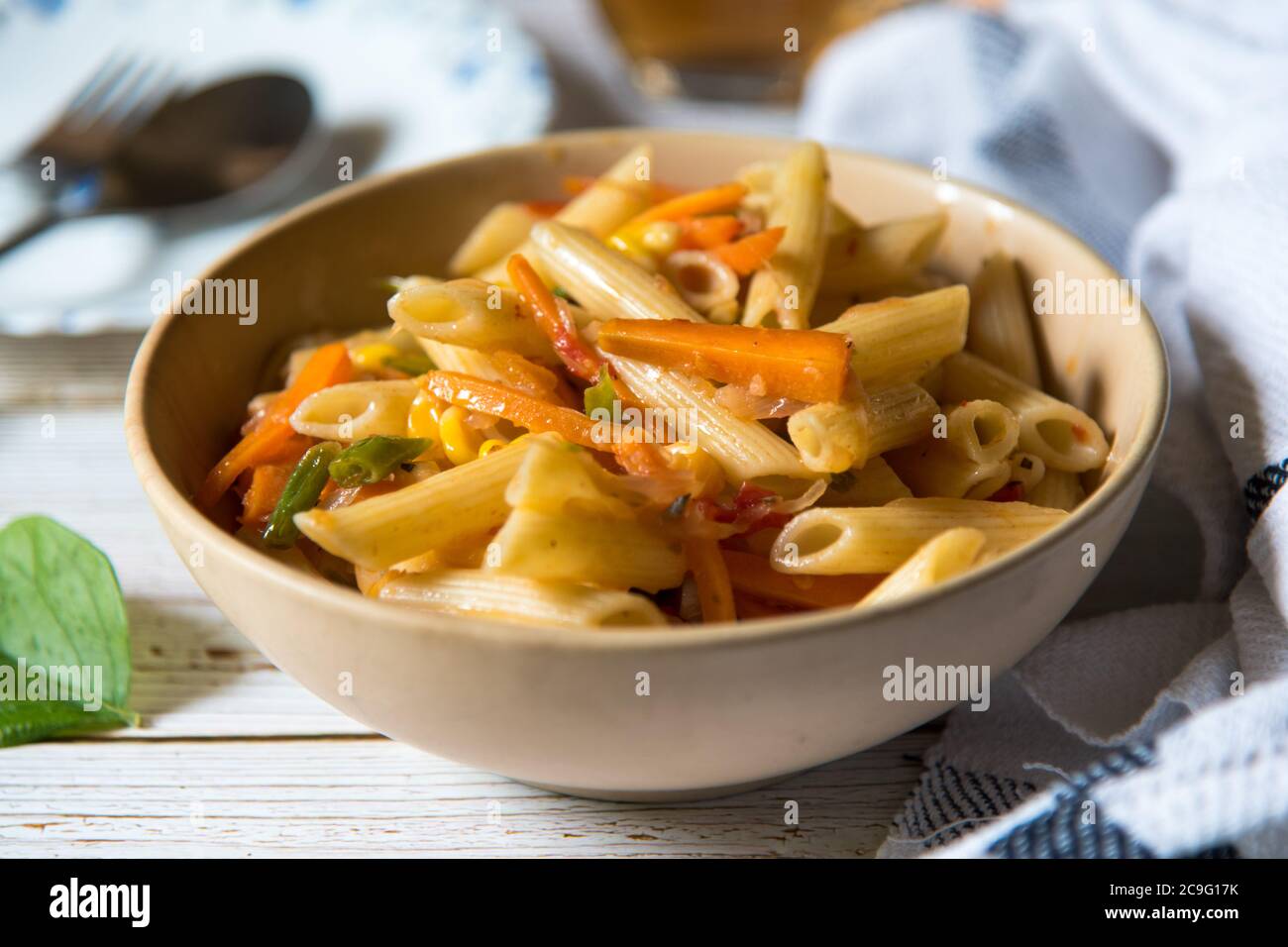 Primo piano di pasta cotta pronta a mangiare servita in una ciotola sullo sfondo Foto Stock
