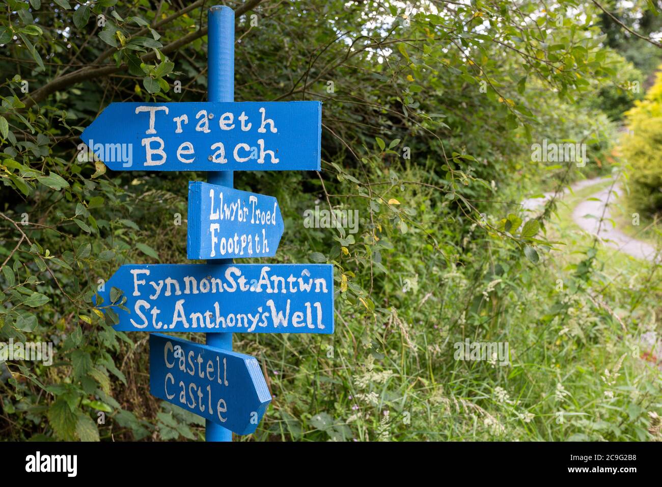 Attraenti cartelli bilingue dipinti (gallesi e inglesi) nel Galles occidentale che indicano la spiaggia, il castello e altre attrazioni Foto Stock