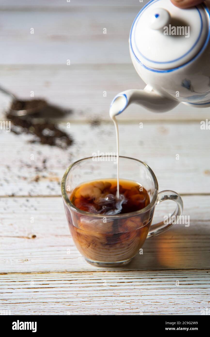 Erogazione del latte dal recipiente del tè Foto Stock