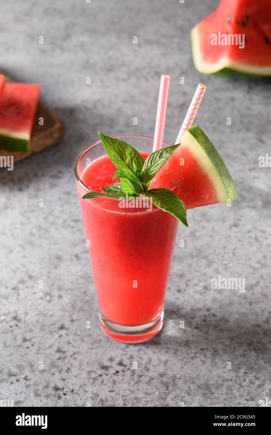 Bicchiere di cocktail di cocomero guarnire la menta su sfondo grigio. Foto Stock