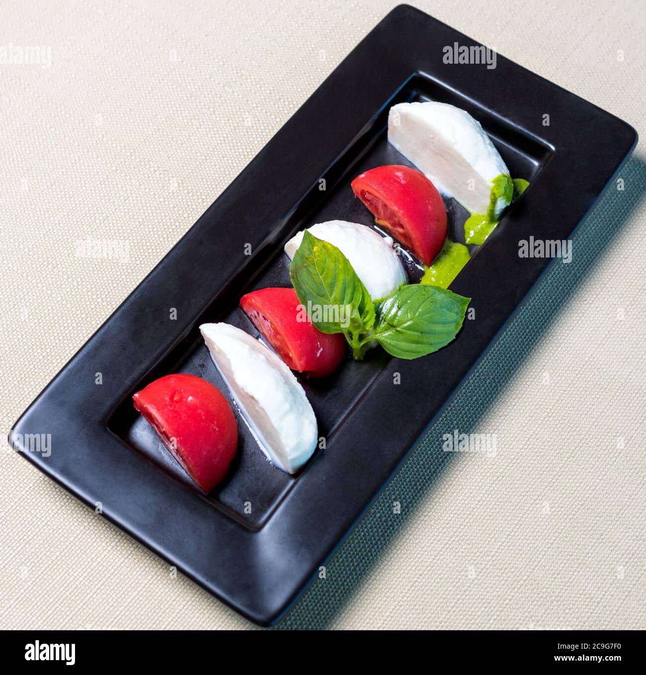 Belle palle di gelato con pomodoro sul piatto nero Foto Stock