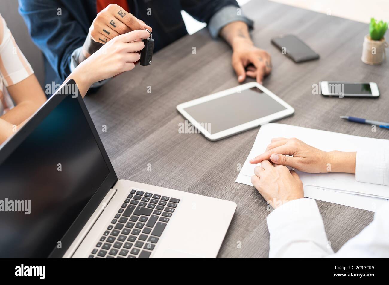 Coppia di clienti che acquistano un'auto nuova in showroom ufficio - Venditore agente che esegue un contratto di leasing del veicolo Foto Stock