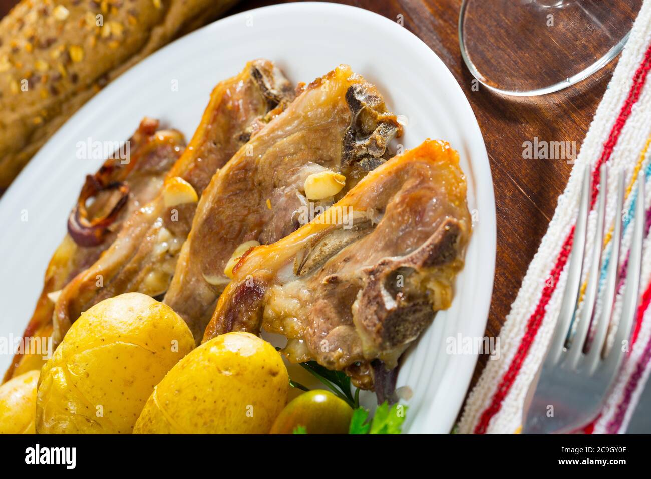 Costolette di mouton cotte lentamente con patate, piatto spagnolo Costillas de cordero Foto Stock
