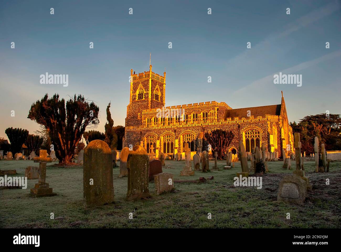 Il sole di prima mattina illumina la chiesa di Stratford St Mary a Suffolk, Regno Unito Foto Stock