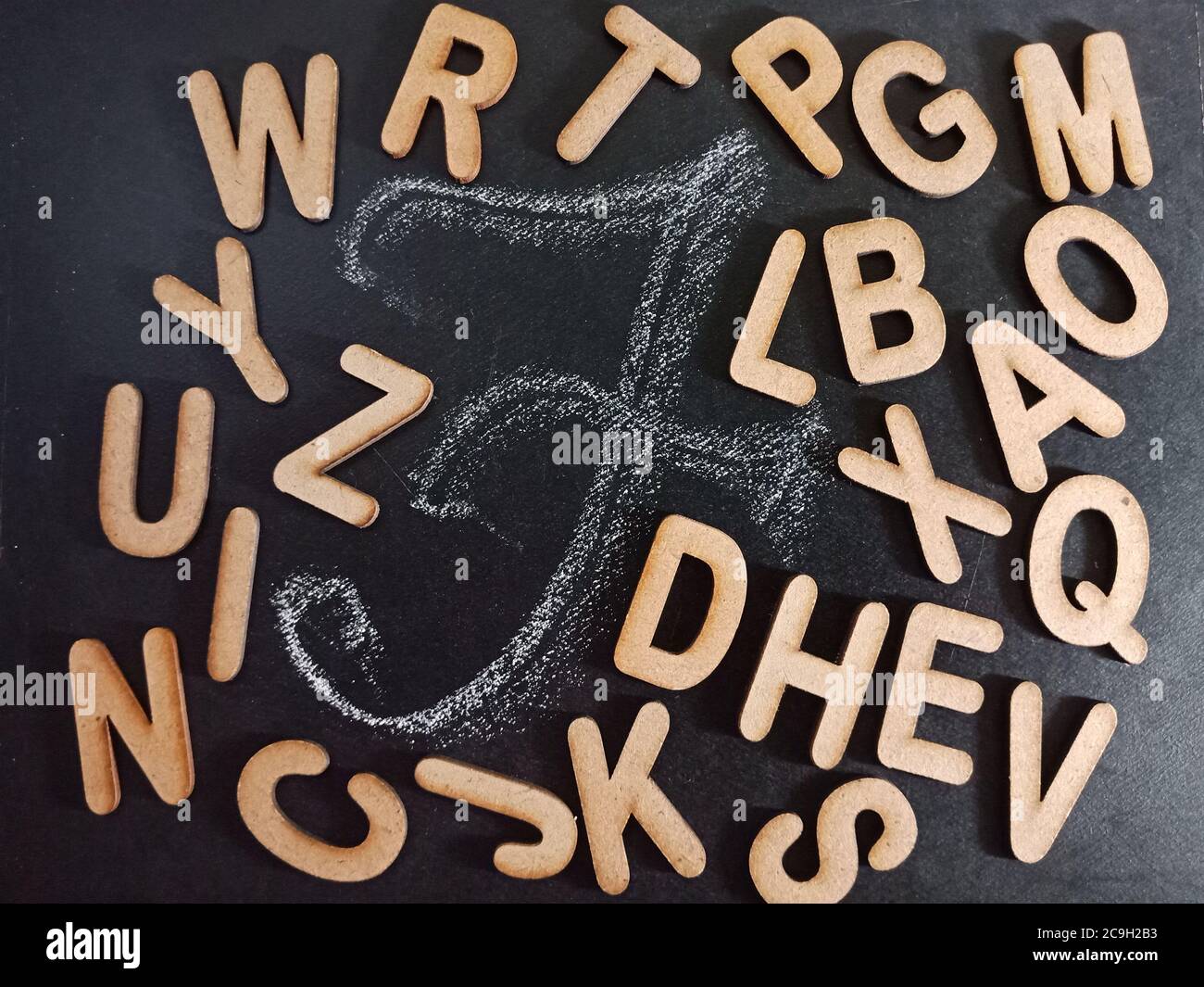 Lettera in alfabeto inglese F con tutta la collezione di testo alfabetico sulla superficie della lavagna nera scritta a mano e sfondo misto in legno. Foto Stock