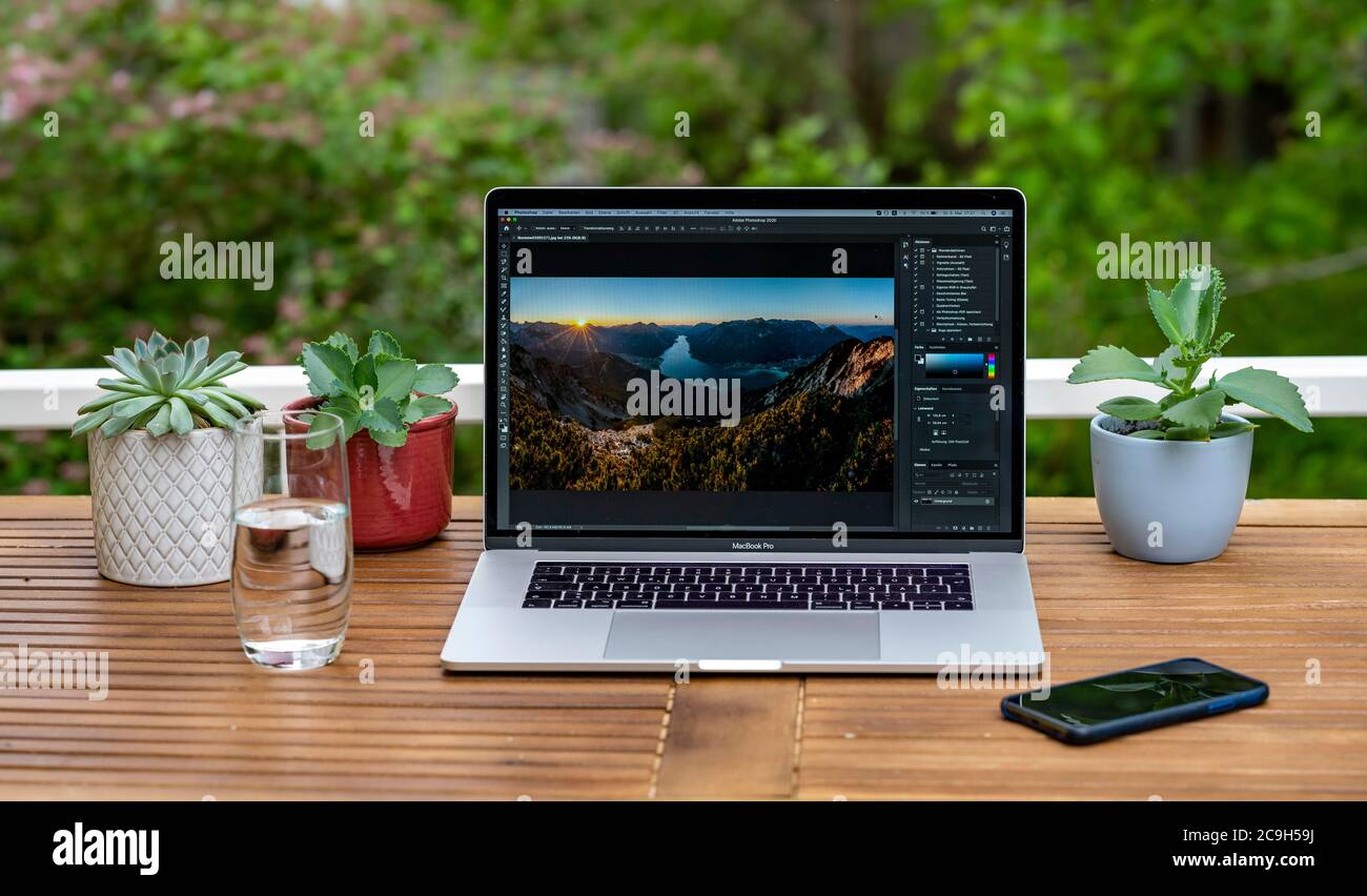 Ufficio domestico con computer portatile, Apple MacBook Pro con iPhone X alla scrivania, editing di immagini con Photoshop, Germania Foto Stock