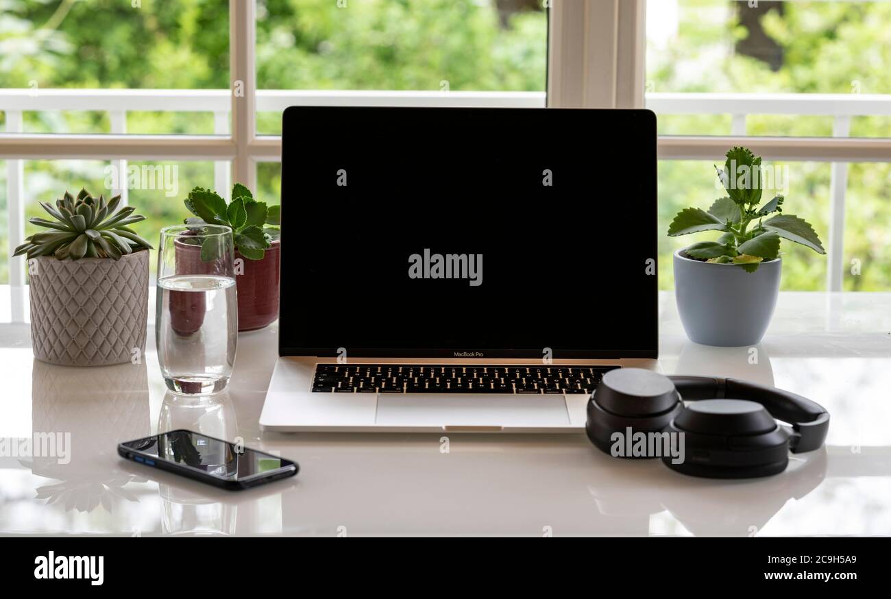 Home Office con computer portatile, Apple MacBook Pro e iPhone X con cuffie alla scrivania, con schermo nero, Monaco, Germania Foto Stock
