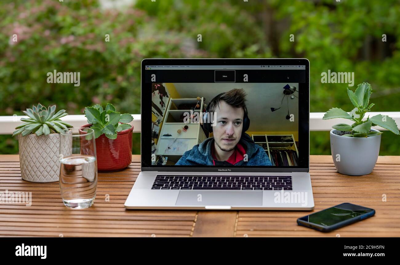 Ufficio domestico con computer portatile, Apple MacBook Pro e iPhone X alla scrivania, con applicazione Zoom durante una videoconferenza, Germania Foto Stock