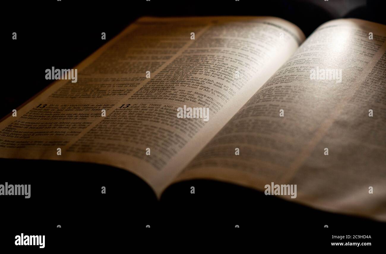 Una Bibbia aperta illuminata dalla luce. Foto Stock