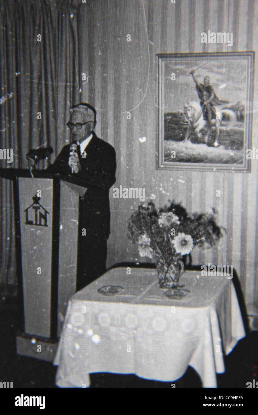 Bella fotografia in bianco e nero degli anni '70 di un oratore adulto che tiene lezioni sul podio. Foto Stock