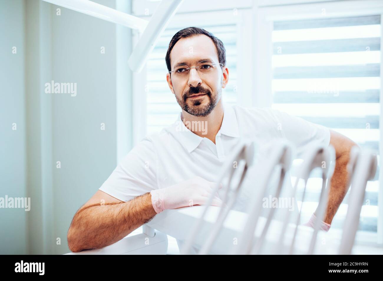 Minsk, Bielorussia - Giugno 11, 2020: Dentista maschile - ritratto aziendale sul posto di lavoro in studio dentistico - medicina privata Foto Stock