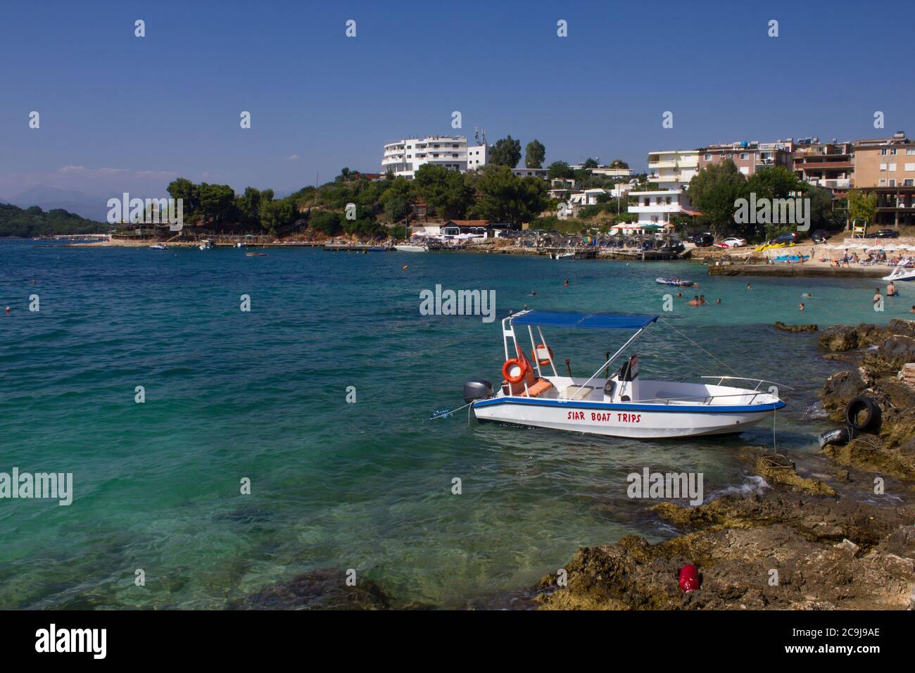 Motoscafo parcheggiato in una tranquilla e panoramica baia di acqua blu sulla spiaggia di Ksamil, Albania Foto Stock