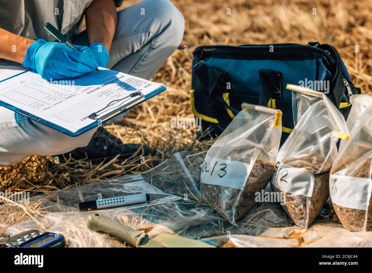 Prova del suolo. Agronomo femminile che prende appunti sul campo. Foto Stock