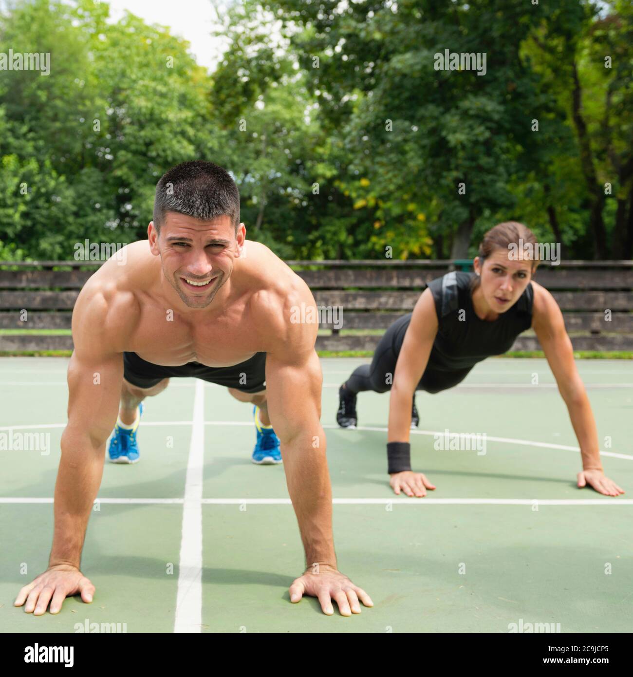 Atleti di sesso maschile e femminile che fanno push-up. Foto Stock