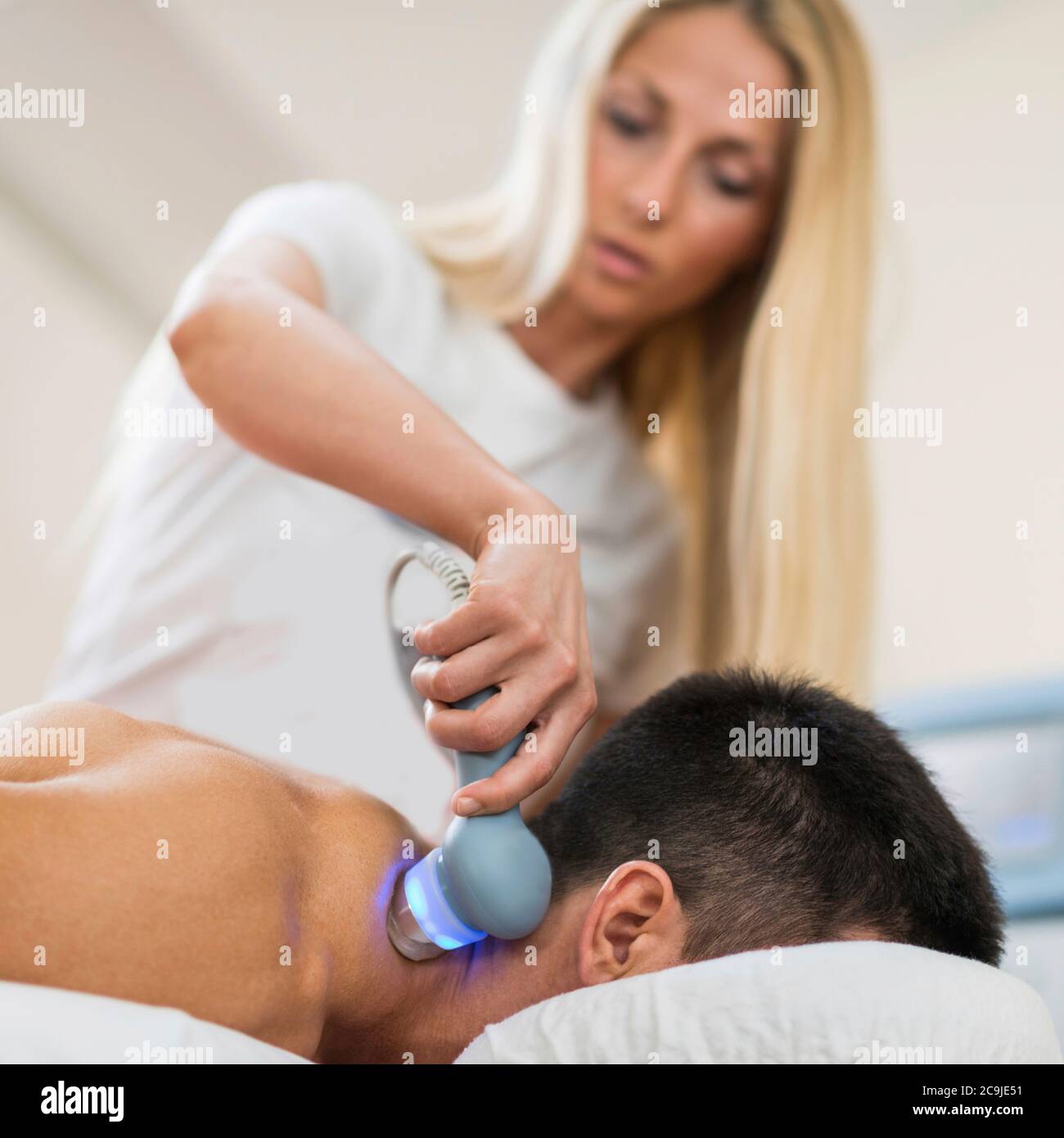 Terapista che cura il dolore al collo con ultrasuoni. Foto Stock