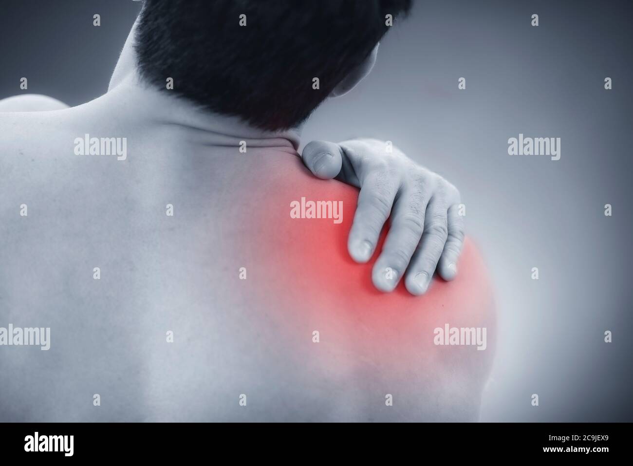 Primo piano immagine di un maschio che tiene la spalla dolorosa. Foto Stock