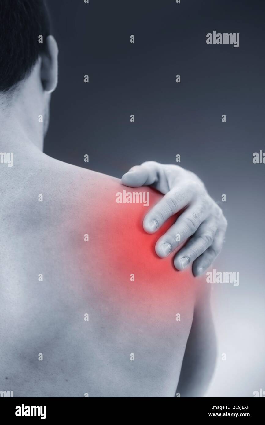 Primo piano immagine di un maschio che tiene la spalla dolorosa. Foto Stock