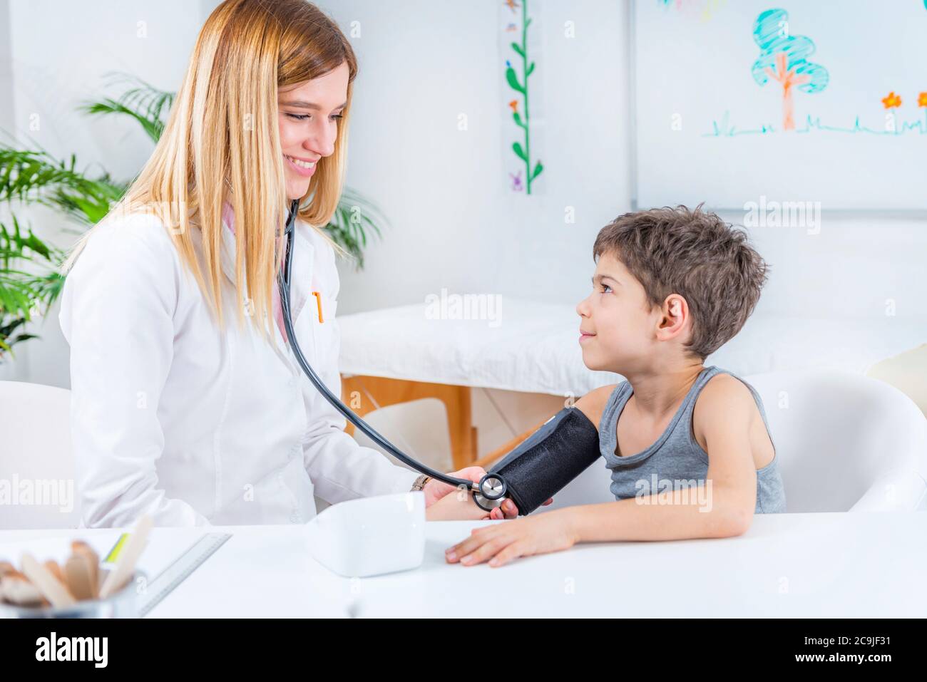 Pediatra che misura la pressione sanguigna del ragazzo. Foto Stock