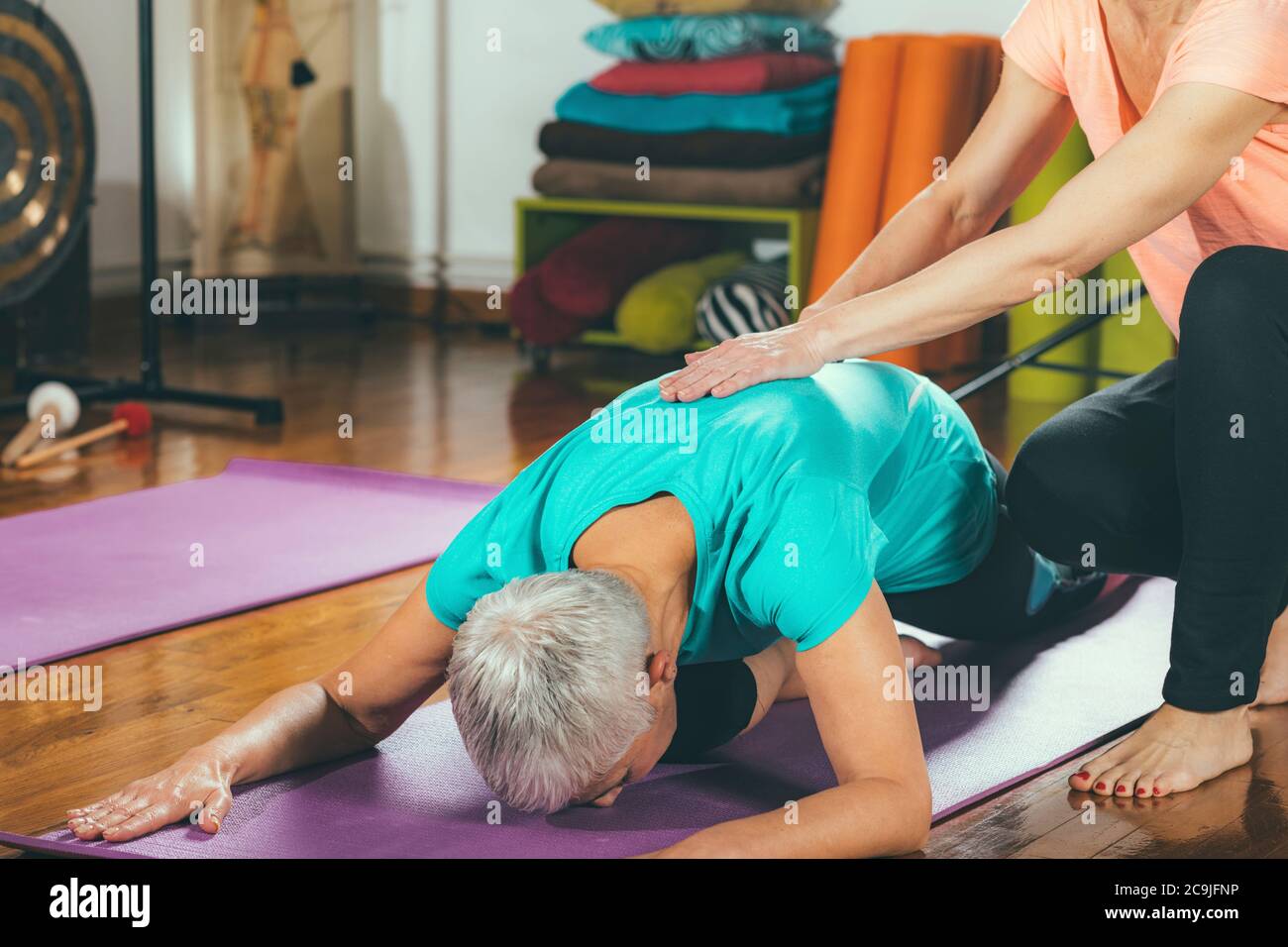 Donna anziana in una lezione privata di yoga. Foto Stock
