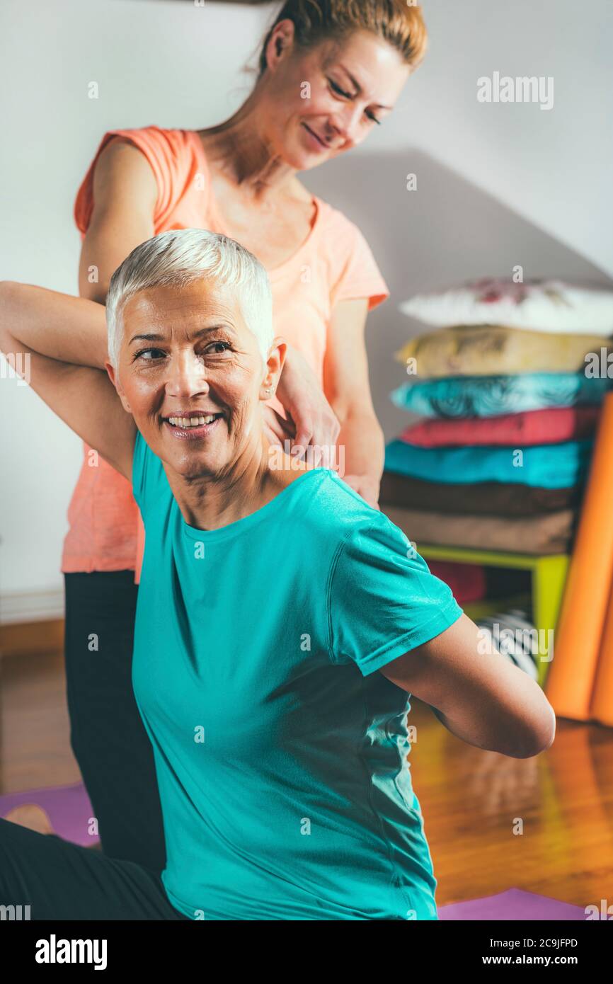 Donna anziana in una lezione privata di yoga. Foto Stock