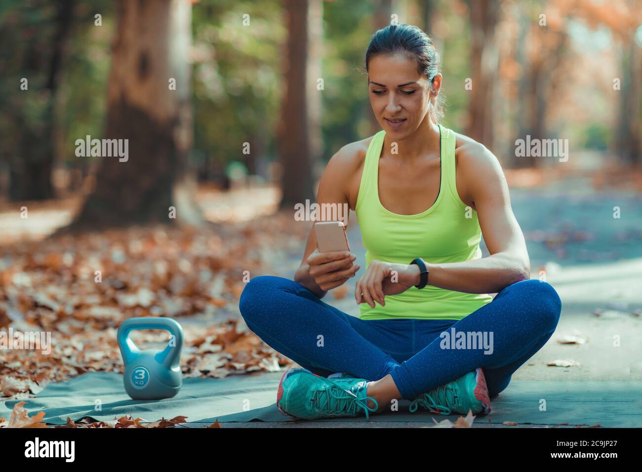Donna che controlla i progressi su Smart Watch dopo l'allenamento all'aperto. Foto Stock
