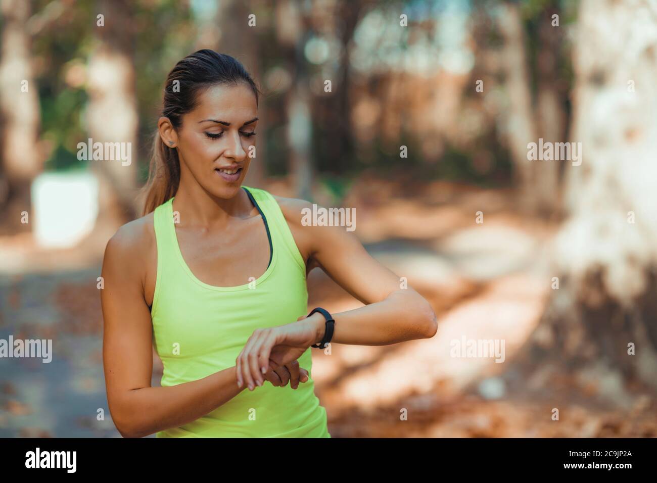 Donna che controlla i progressi su Smart Watch dopo l'allenamento all'aperto. Foto Stock