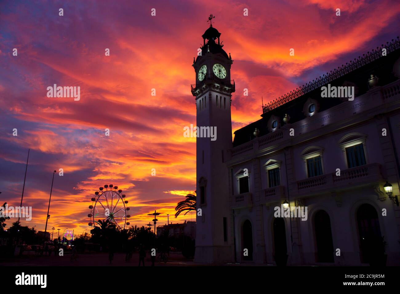 Gennaio 2014. Valencia, Spagna. Edificio doganale nel porto di Valencia durante un tramonto in cui la fiera delle attrazioni è stata installata nella zona Foto Stock