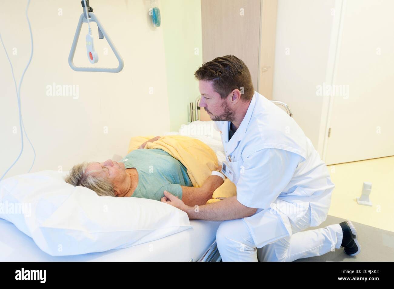 Reparto di ospedale geriatrico. Infermiere che aiuta un paziente confuso nel reparto geriatrico di un ospedale. Foto Stock