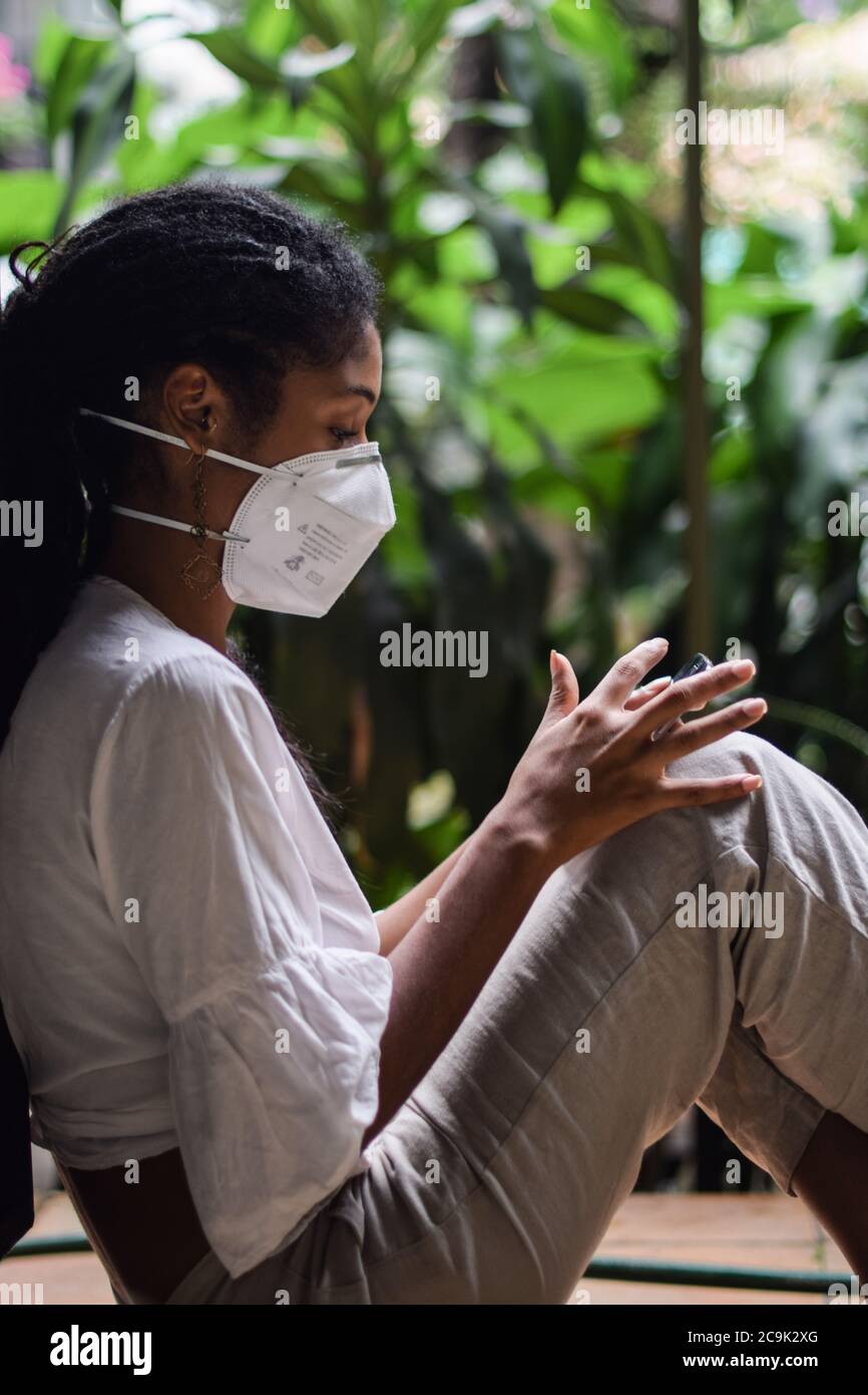 Giovane donna che indossa una maschera a Bogotà, Colombia, durante lo scoppio del 2019-20 del nuovo coronavirus SARS-COV-2. SARS-COV-2 causa un i respiratorio Foto Stock