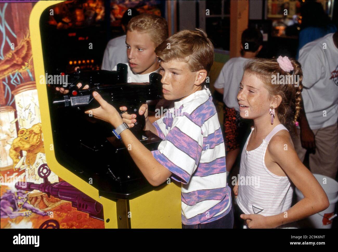 I bambini americani in arcade che giocano un gioco di tiro con la pistola. Foto Stock