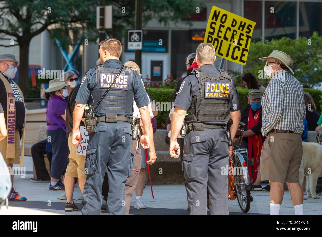 Detroit, Michigan, Stati Uniti. 31 luglio 2020. La polizia del Dipartimento federale della sicurezza interna chiacchiera con i manifestanti prima di un raduno che si oppone al piano del presidente Trump di inviare la polizia federale a Detroit. I manifestanti hanno affermato che il denaro federale dovrebbe invece essere utilizzato per il sostegno alla salute e al reddito durante la pandemia del coronavirus. Credit: Jim West/Alamy Live News Foto Stock