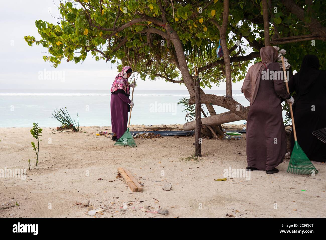 Hulumale / Maldive - 20 agosto 2019: Donna musulmana con hijab spazzatrice scopa turistica zona spiaggia Foto Stock