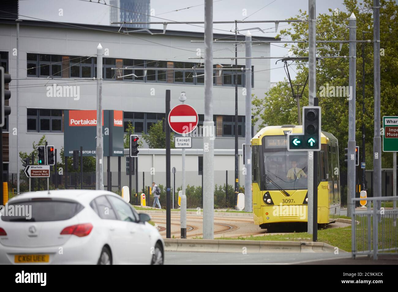 Nessun ingresso alle auto un tram METROLNK che opera attraverso la zona industriale di Trafford Park Greater Manchester Foto Stock