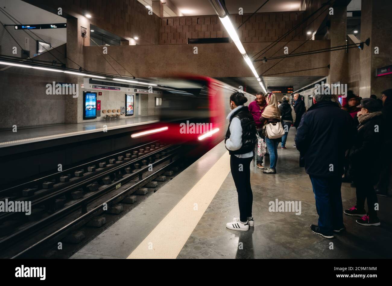 LISBONA, PORTOGALLO - 2 FEBBRAIO 2019: Persone in attesa sulla piattaforma della stazione della metropolitana Alameda a Lisbona, Portogallo, il 2 febbraio 2019, con un r Foto Stock
