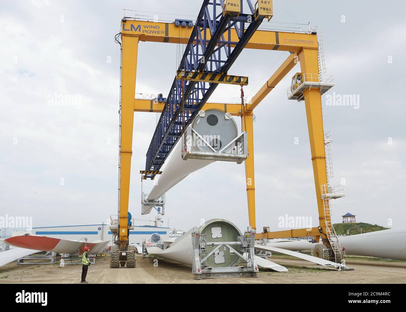Qinhuangdao, provincia cinese di Hebei. 1 agosto 2020. Un lavoratore gestisce una gru a portale per sollevare le pale della turbina eolica nella zona di sviluppo economico e tecnologico di Qinhuangdao, nella provincia di Hebei, 1 agosto 2020. A partire dal 2020, la zona di sviluppo economico e tecnologico di Qinhuangdao ha introdotto una serie di politiche benefiche per aiutare i produttori a raggiungere una crescita costante e ottimizzare gli aggiustamenti strutturali. Credit: Yang Shiyao/Xinhua/Alamy Live News Foto Stock