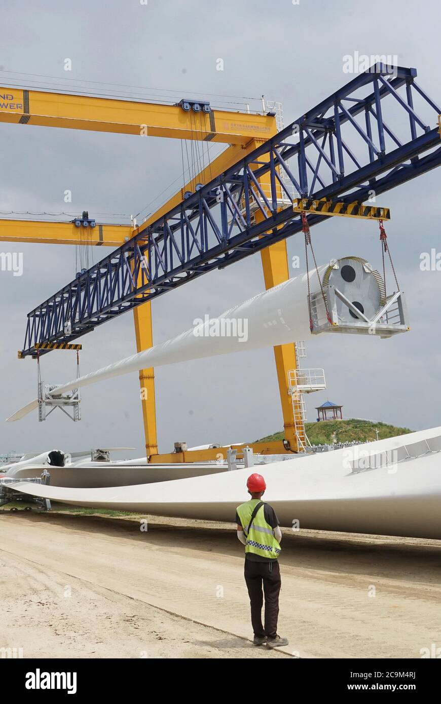 Qinhuangdao, provincia cinese di Hebei. 1 agosto 2020. Un lavoratore gestisce una gru a portale per sollevare le pale della turbina eolica nella zona di sviluppo economico e tecnologico di Qinhuangdao, nella provincia di Hebei, 1 agosto 2020. A partire dal 2020, la zona di sviluppo economico e tecnologico di Qinhuangdao ha introdotto una serie di politiche benefiche per aiutare i produttori a raggiungere una crescita costante e ottimizzare gli aggiustamenti strutturali. Credit: Yang Shiyao/Xinhua/Alamy Live News Foto Stock