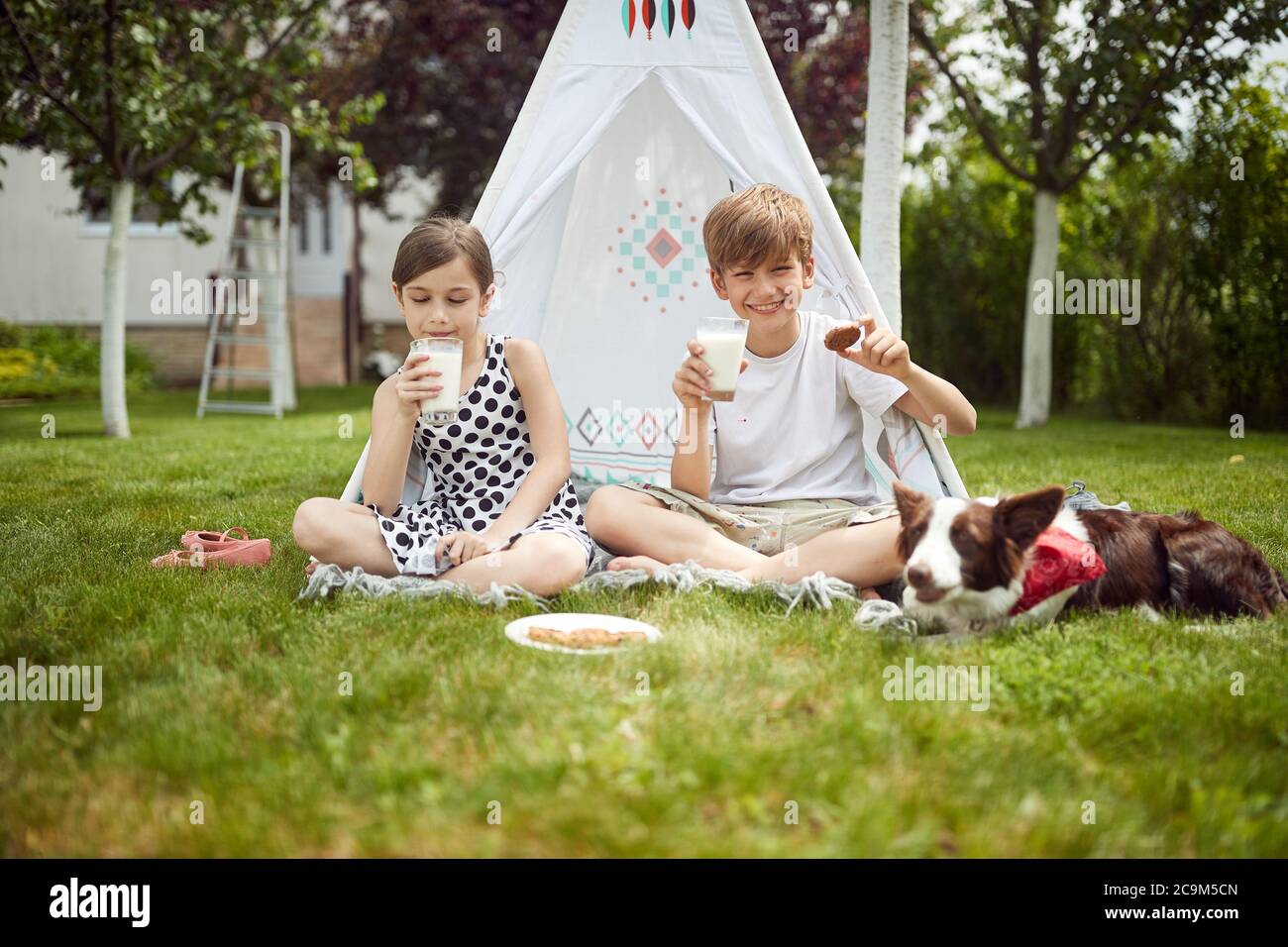 I bambini si accamparono in un cortile sul bel tempo Foto Stock