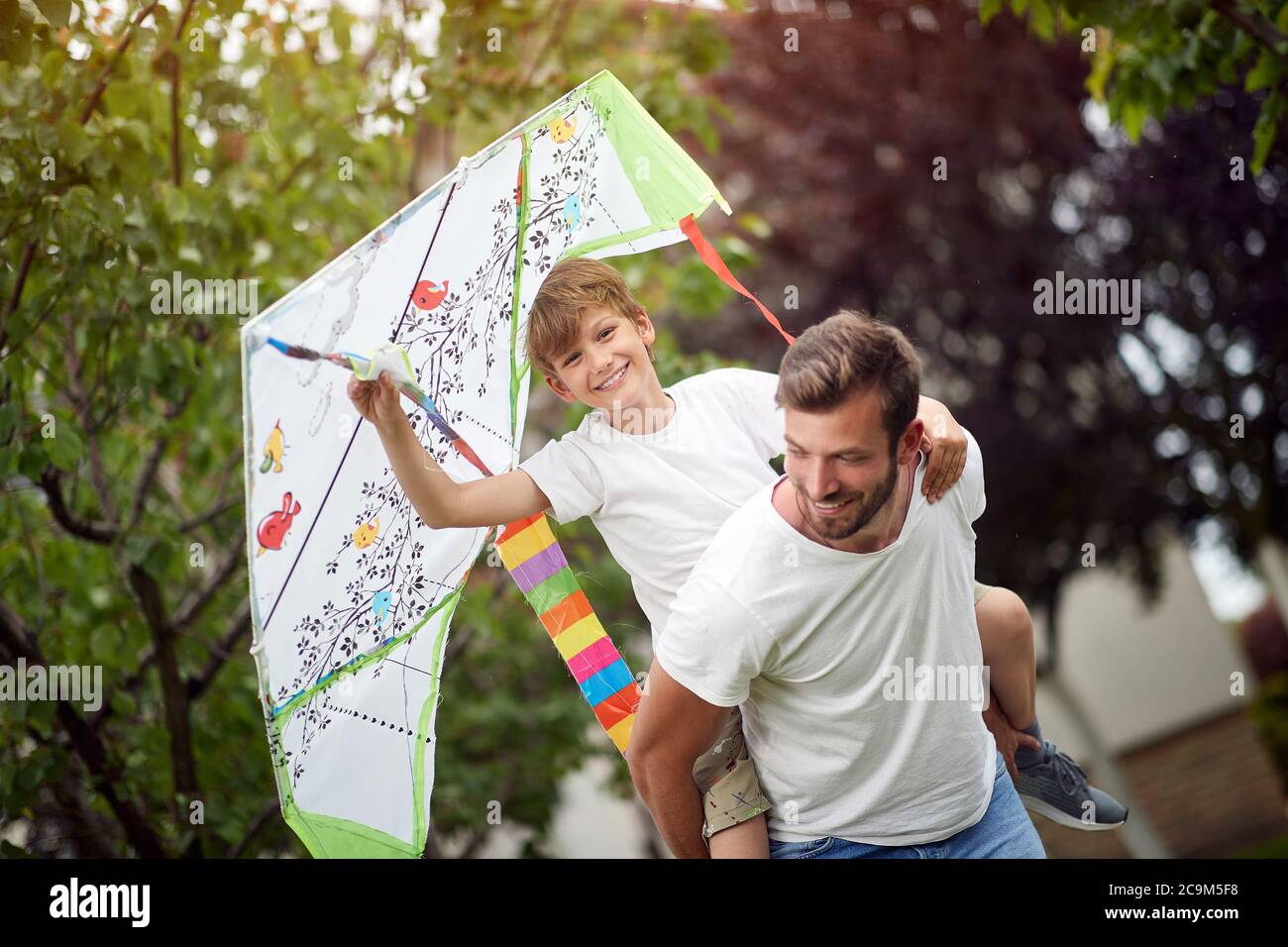 Padre e figlio giocano in giardino in una bella giornata Foto Stock