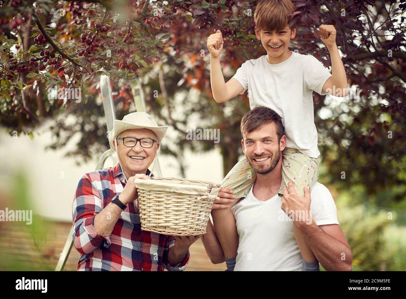 Felice famiglia in posa in giardino in una bella giornata Foto Stock