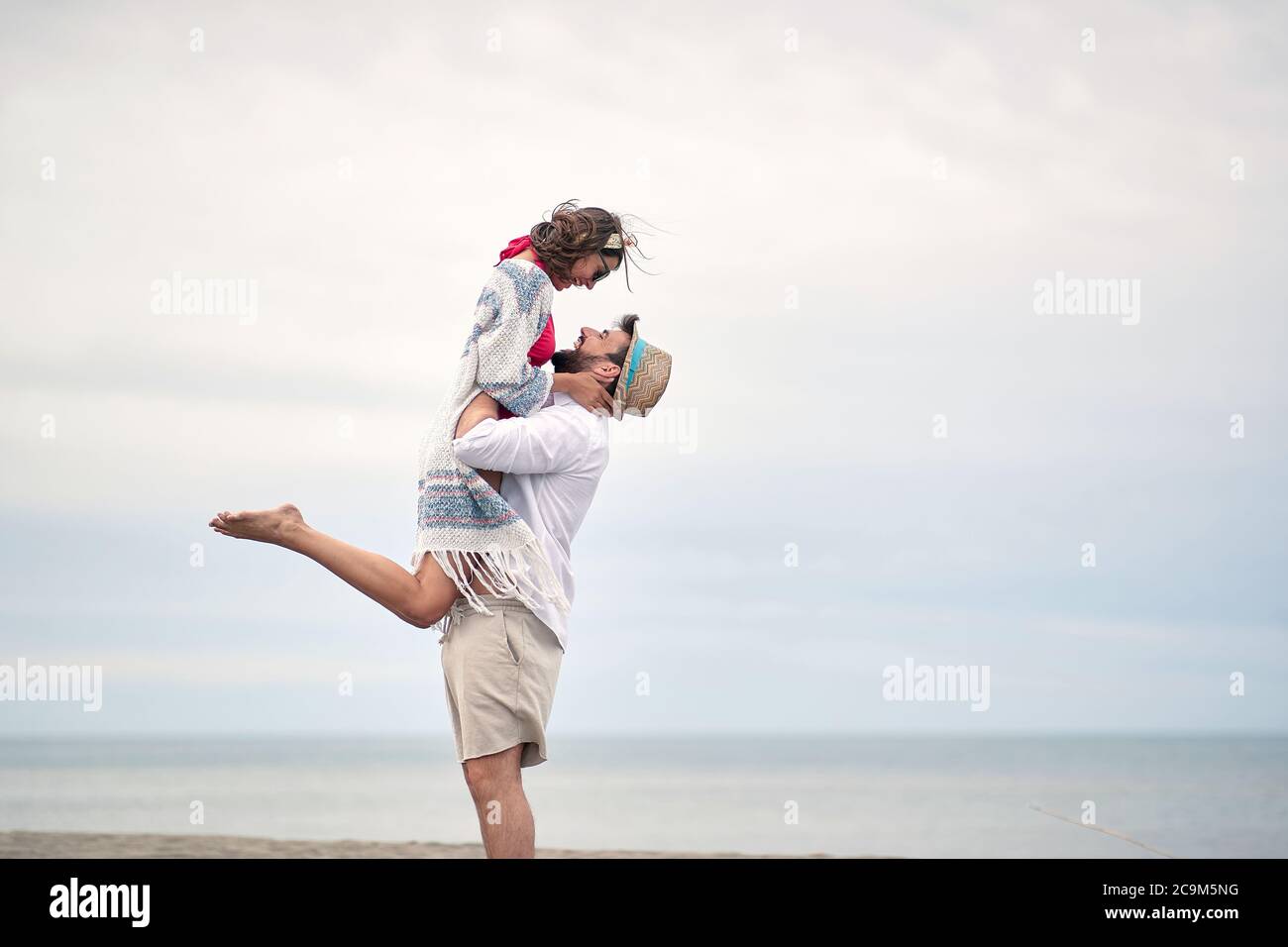 Condivisione tenera Moments.Young felice coppia in un abbraccio sulla spiaggia. Foto Stock