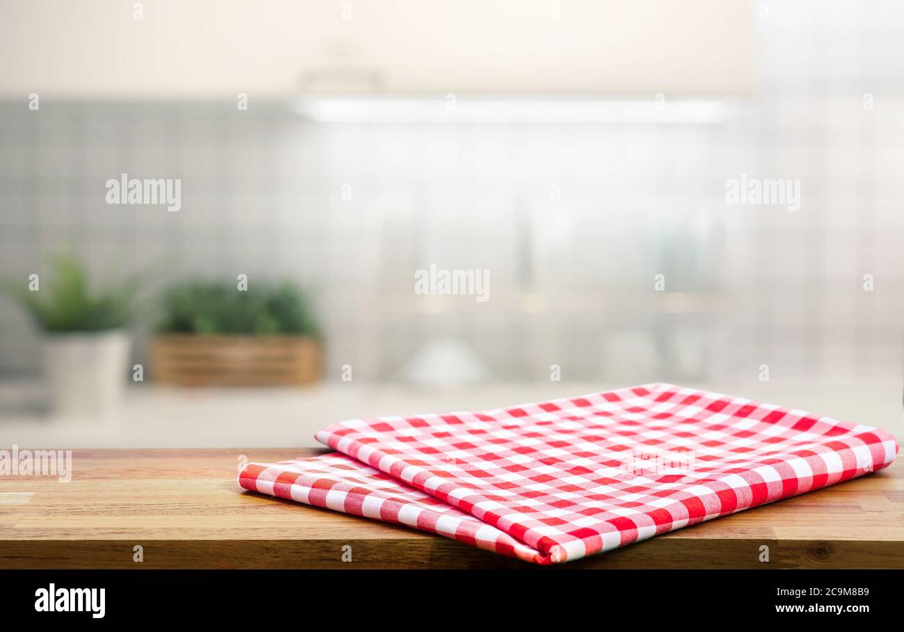 Tessuto rosso, panno su tavolo di legno su piano cucina sfocata (stanza)sfondo.per montaggio prodotto display o design chiave layout visivo. Foto Stock