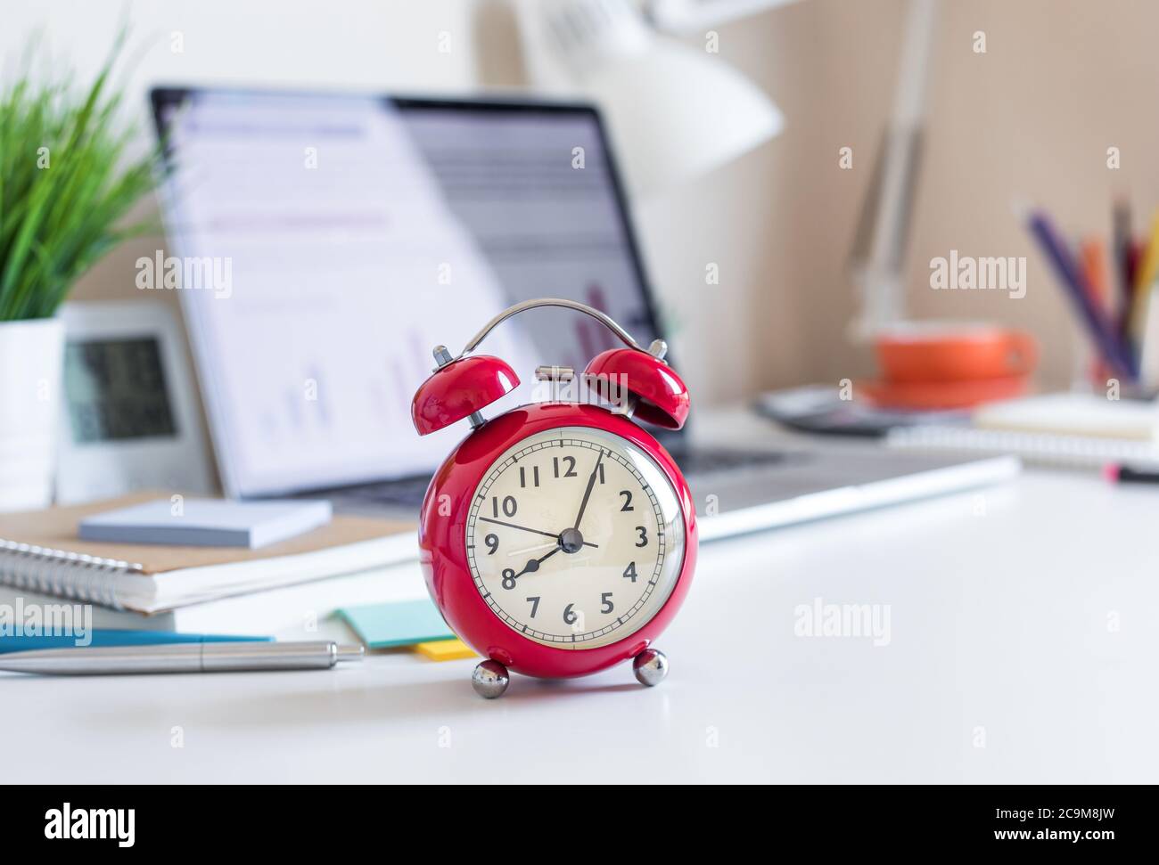 Concetti aziendali con orologio rosso sulla scrivania.per l'analisi degli investimenti, in attesa di idee sucess.ora e giorno di lavoro Foto Stock